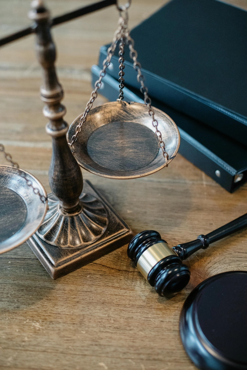 Viviana M. Breitbach – Anwältin – Das Bild zeigt einen hölzernen Hammer und die Justitia-Waage auf einem Holztisch, die üblicherweise das Rechtssystem und die Gerechtigkeit symbolisieren.